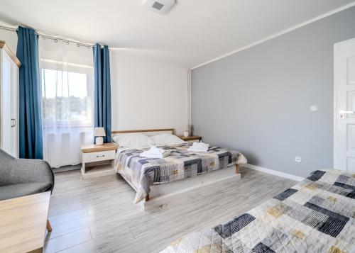 a bedroom with a bed and a couch and a window at Pablo in Niechorze