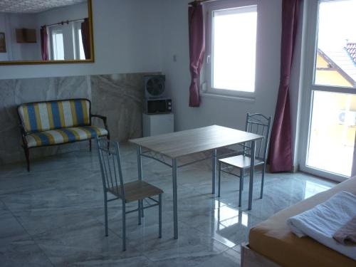 a living room with a table and chairs and a couch at R1 Rolléder Apartman-ház in Siklós