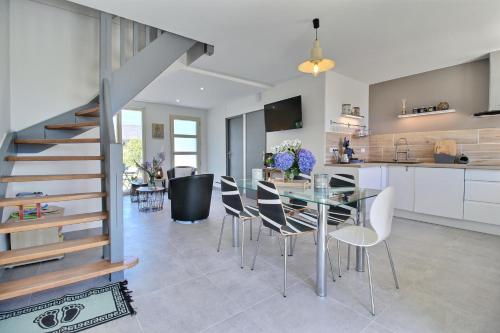 une cuisine et une salle à manger avec une table et des chaises en verre dans l'établissement GRAND GITE MER ET CAMPAGNE AVEC DEUX LOGEMENTS INDEPENDANTS COMMUNIQUANTS 6 chambres 4 salles de bains, à Férel
