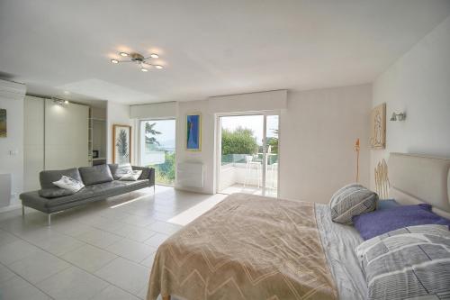 a bedroom with a bed and a couch at FRGK "Villa Hameau des collines" in Le Cannet