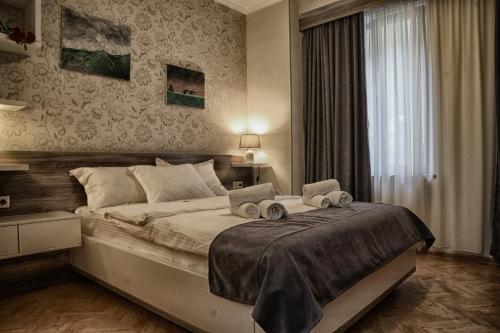 Un dormitorio con una cama grande y una ventana en Hotel Four Brothers en Tiflis