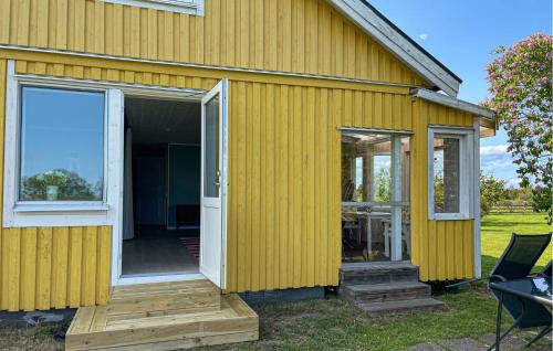 a yellow house with a sliding glass door at Holiday Home N, Honungstorp Löttorp in Löttorp