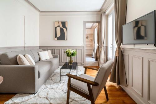 un salon avec un canapé et une télévision dans l'établissement Renovated apartment near Trocadero with elevator, à Paris