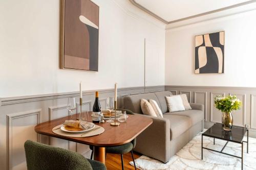 un salon avec une table et un canapé dans l'établissement Renovated apartment near Trocadero with elevator, à Paris