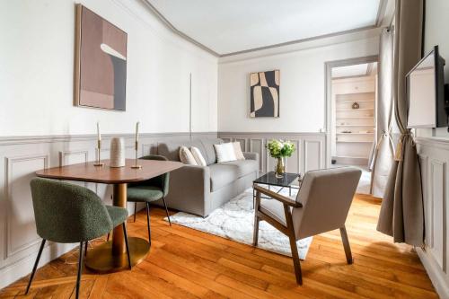 un salon avec une table, des chaises et un canapé dans l'établissement Renovated apartment near Trocadero with elevator, à Paris