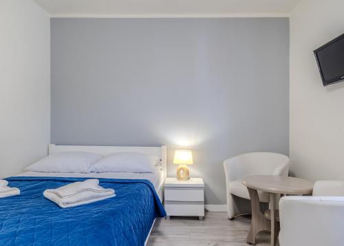 a white bedroom with a bed and a table at Pablo in Niechorze
