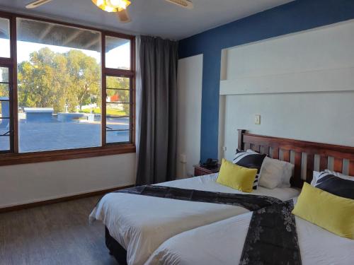 a bedroom with two beds and a large window at Hoedjiesbaai Hotel in Saldanha