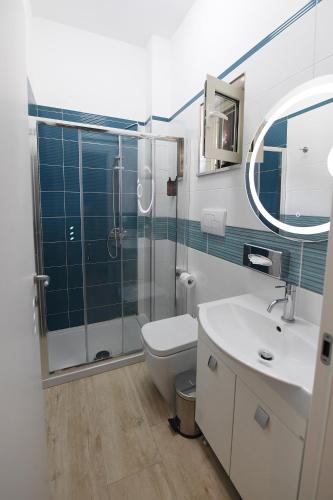 a bathroom with a shower and a toilet and a sink at Scilla SeaFront Rooms in Scilla
