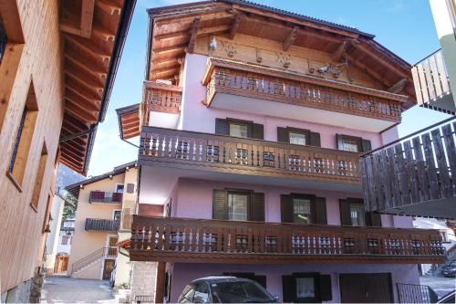 a building with wooden balconies and a car parked in front at Casa March 1 in Moena
