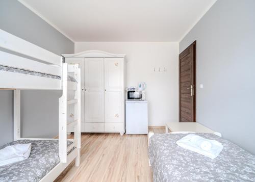 a bedroom with two bunk beds and a kitchen at Pablo in Niechorze
