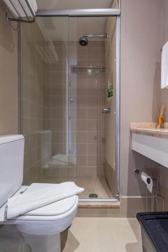 a bathroom with a glass shower with a toilet at LFlats Hotel Alameda Lorena Jardins in Sao Paulo
