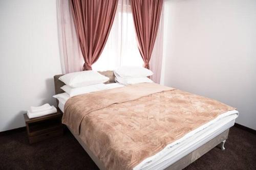 Un dormitorio con una cama grande con ventana. en Villa Palma - With Free Parking, en Mostar