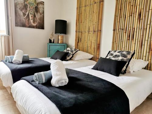 - 2 lits avec des draps noirs et blancs dans une chambre dans l'établissement Le Sarment Cottage - F3 Luxury with Pool, à La Croix-Valmer