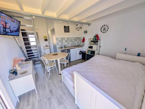 une chambre avec un lit et une table et une cuisine dans l'établissement Le Futuronid, à Chasseneuil-du-Poitou