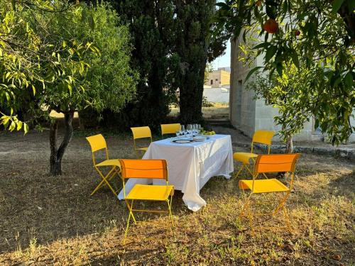 a table with yellow chairs and a white table cloth at Suite Royale Palazzo Villani Lubelli in Cannole