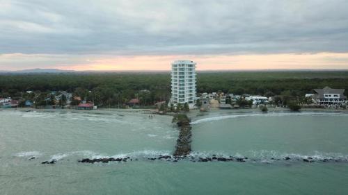 an island in the water in front of a building at Magico PentHouse Duplex Frente al Mar 3 Habs FB112 in Coveñas