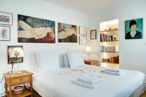 - une chambre avec un lit blanc orné de peintures murales dans l'établissement Paris Bastille Rollin residence, à Paris