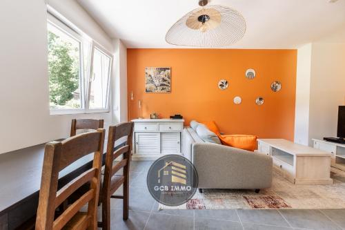un salon avec des murs orange et un canapé et une table dans l'établissement Le Ferjus 2 - Parking privé - Centre Ville, à Grenoble