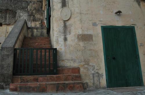 a staircase with a green door next to a building at Slow Living B&B in Matera
