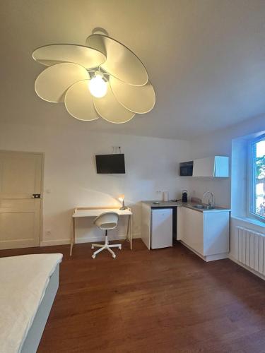 une chambre avec un lit et une cuisine avec un ventilateur de plafond dans l'établissement La chambre de Bouloc confortable et calme, à Bouloc