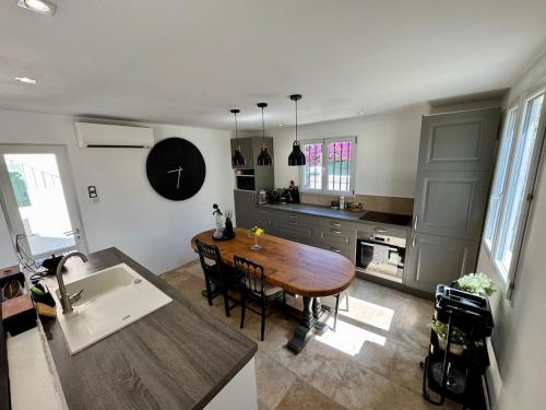 une cuisine avec une table en bois et une salle à manger dans l'établissement Maison provençale en bord de mer, à Vallauris
