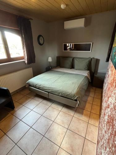 a bedroom with a bed and a clock on the wall at Relax Garden in Hulshout