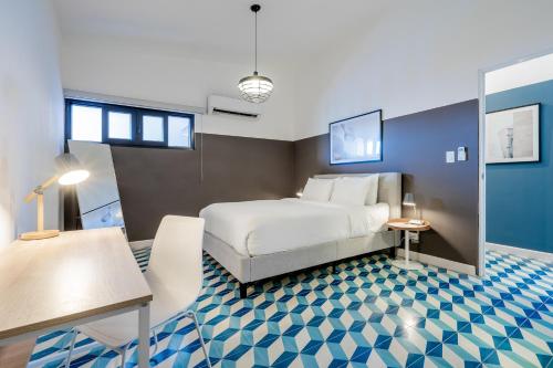 a hotel room with a bed and a desk at La Manzana By Wynwood House in Paloma
