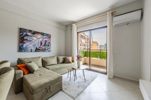 a living room with a couch and a table at Green Tea Apartment in Vlorë