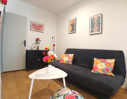 un salon avec un canapé noir et une table dans l'établissement le Notre dame-Centre ville-Gare, à Nîmes