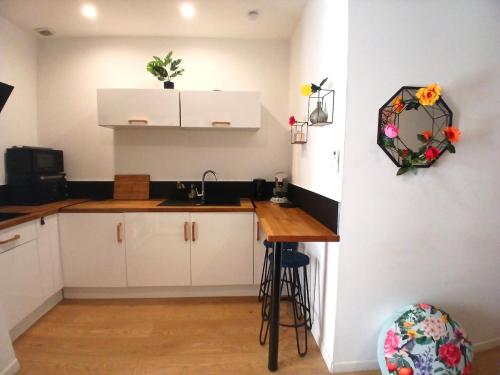 une cuisine avec des armoires blanches et un comptoir en bois dans l'établissement le Notre dame-Centre ville-Gare, à Nîmes