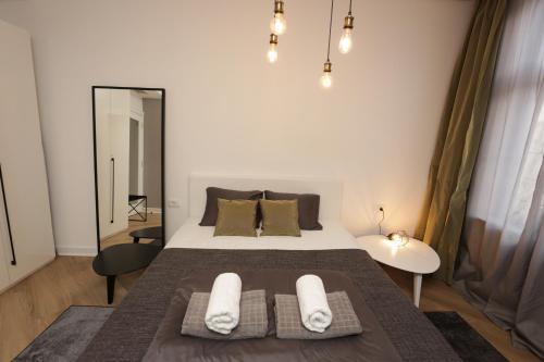 a bedroom with a bed with two towels on it at Moment Boutique Apartments in Belgrade