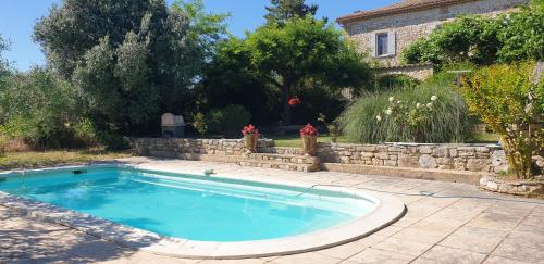 - une piscine dans une cour dotée d'un mur en pierre dans l'établissement Mas provençal, piscine privée, Uzès, à Aubussargues
