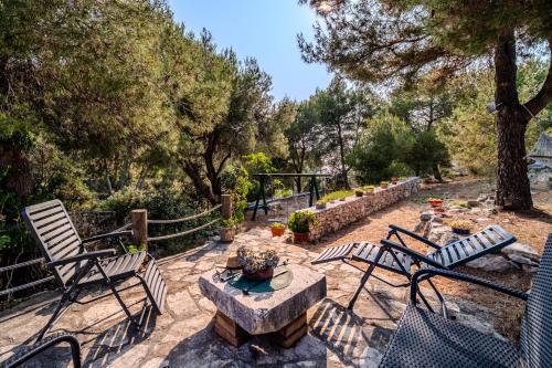 a patio with chairs and a table and a fence at Holiday Home Sarbunara in Milna