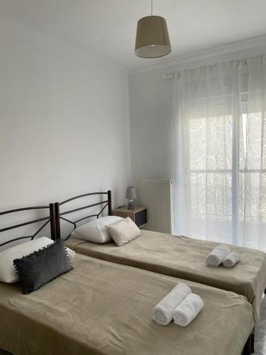 two beds in a bedroom with towels on them at Isolde Apartment in Kallithea Halkidikis