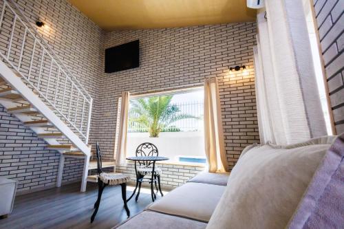 a room with a bed and a table and a window at Къщата с рибките in Sinemorets