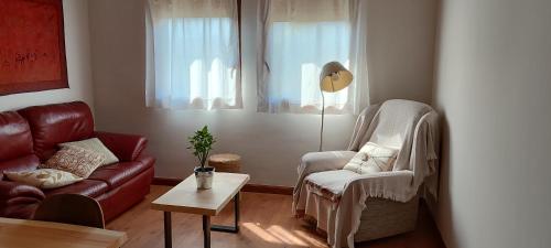 a living room with a couch and a chair and a table at Alameda 2 in Alameda del Valle