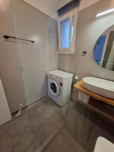 a bathroom with a washing machine and a sink at sea melody tinos 2 in Agios Sostis