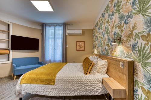 a bedroom with a bed and a blue chair at Hôtel Mistral Comédie Saint Roch in Montpellier