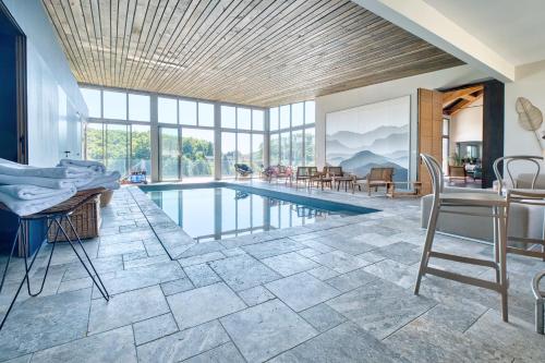 - un salon avec une piscine, une table et des chaises dans l'établissement La Grange de Louvadour, à Sadroc