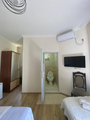 a bedroom with a bathroom with a toilet in it at Guest House Deme in K'obulet'i