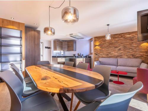 une salle à manger avec une table et des chaises en bois dans l'établissement Prestigieux appartement avec balcon, Wi-Fi et services inclus - FR-1-314-205, à Morzine