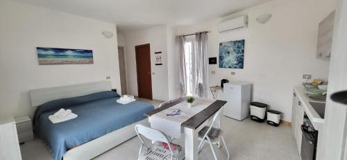 Un dormitorio con una cama y una mesa dentro. en Casa Vacanze Sole della Sardegna, en Portoscuso