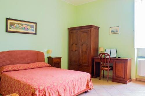 a bedroom with a bed and a desk and a chair at Palazzo Albini in Albanella
