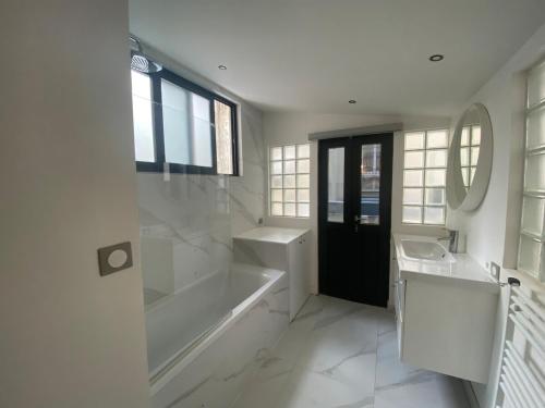une salle de bain avec une baignoire, un lavabo et un miroir dans l'établissement Amazing flat facing Bon Marché, à Paris