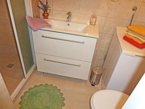 a bathroom with a sink and a toilet and a rug at Apartment Vanda in Splitska