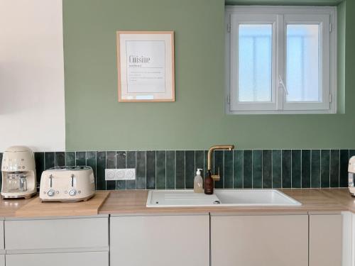 un comptoir de cuisine avec un évier et une fenêtre dans l'établissement Villa Rompsay, à La Rochelle
