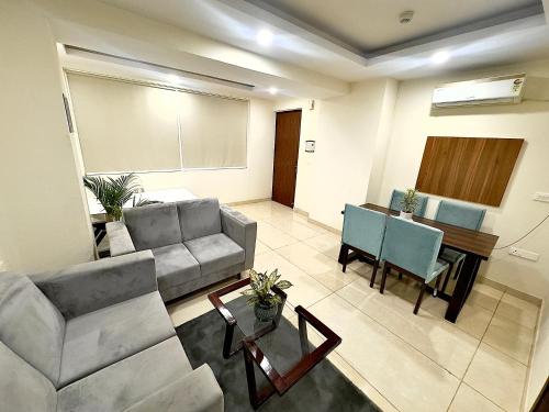 a living room with a couch and a table at High Rise Lavish Room with Jacuzzi & Amazing View in zirkapur in Zirakpur