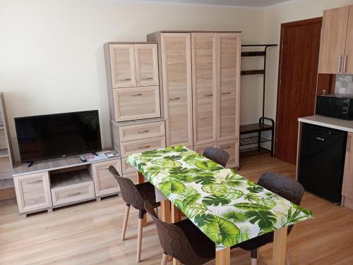 a living room with a dining table and a kitchen at Domek pod Lipą in Nienaszów