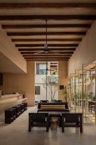 a room with a table and some chairs and a ceiling at NABOA Hotel Tulum in Tulum