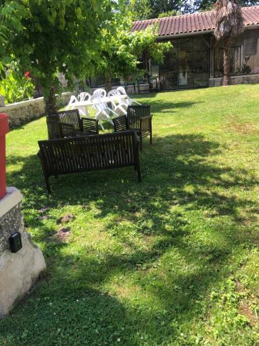 un groupe de bancs assis dans une cour dans l'établissement Aux Chênes Centenaires, à Sos